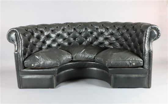 A buttoned black leather concave settee, W.7ft D.3ft 6in. H.3ft